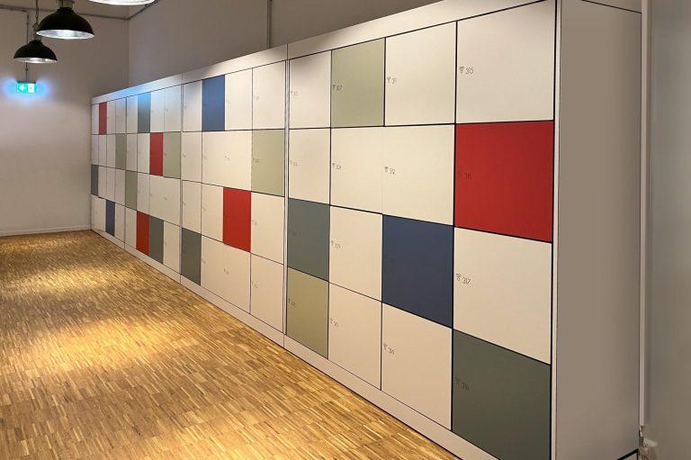 Armoire à casiers et vestiaires en HPL Mur de casiers colorés avec des panneaux rouges, bleus, verts et gris.