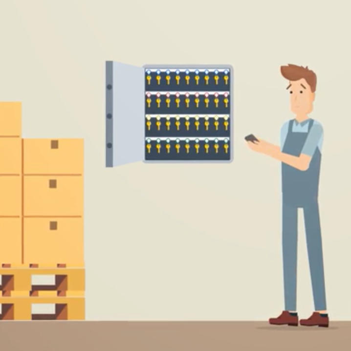 DigiClés - Gestion de clés via NFC (RFID) Un homme en salopette regarde une armoire à clés, près de cartons empilés.